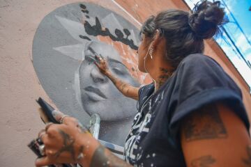 Hanna Lucatelli realizando pintura mural, GP 2019. 