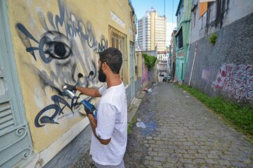 Leandro Ice realizando pintura grafite na Ladeira do Livramento. GP 2019. 