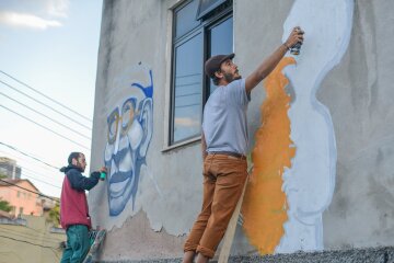 Detalhe de artistas grafitando muros no Festival Galeria Providência 2019. 