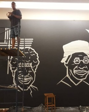 Diego de Deus em processo de trabalho no Mural em Tape Arte na galeria do Museu de Arte do Rio, FLUP 2019. 